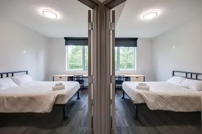 two beds in a room with two windows at Residence & Conference Centre - Oakville in Oakville