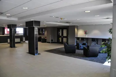 a lobby with chairs and tables in a building at Residence & Conference Centre - Oakville in Oakville