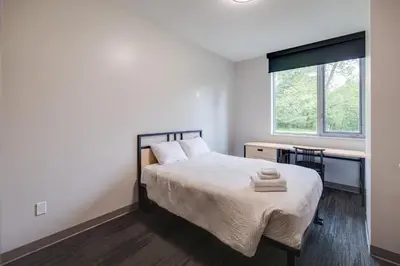 a bedroom with a bed and a desk and a window at Residence & Conference Centre - Oakville in Oakville
