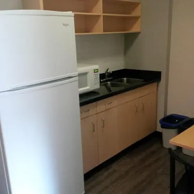 a kitchen with a white refrigerator and a sink at Residence & Conference Centre - Oakville in Oakville