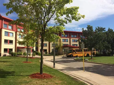a yellow school bus parked in front of a building at Residence & Conference Centre - Oakville in Oakville