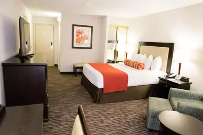 a hotel room with a large bed and a couch at Admiral Inn Hamilton in Hamilton