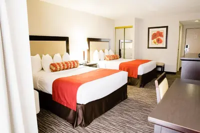 a hotel room with two beds and a kitchen at Admiral Inn Hamilton in Hamilton