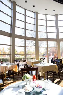 a restaurant with tables and chairs and large windows at Admiral Inn Hamilton in Hamilton