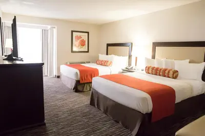 a hotel room with two beds and a television at Admiral Inn Hamilton in Hamilton