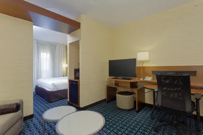 a hotel room with a bed and a desk with a computer at Fairfield Inn & Suites by Marriott Belleville in Belleville