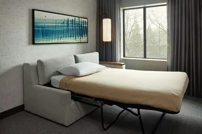 a hotel room with a bed and a couch at Courtyard by Marriott Hamilton in Hamilton