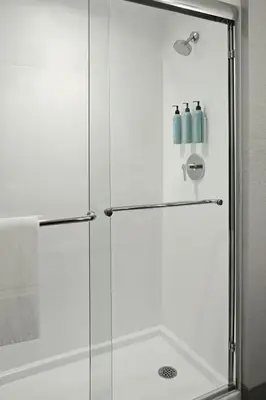 a shower with a glass door and two bottles at Courtyard by Marriott Hamilton in Hamilton