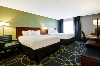 a hotel room with two beds and a chair at Fairfield Inn & Suites by Marriott Guelph in Guelph