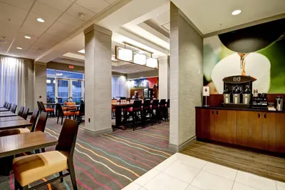 a restaurant with a bar and tables and chairs at Fairfield Inn & Suites by Marriott Guelph in Guelph