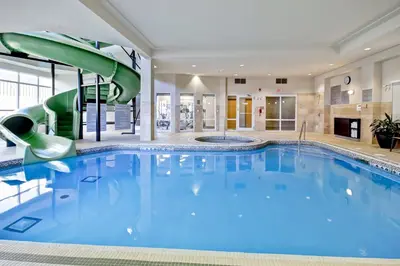 a large swimming pool with a slide in a building at Fairfield Inn & Suites by Marriott Guelph in Guelph