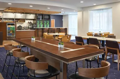 a restaurant with a large wooden table and chairs at Courtyard by Marriott Toronto Markham in Markham