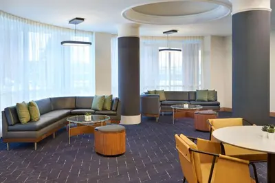 a living room with couches and tables and chairs at Courtyard by Marriott Toronto Markham in Markham