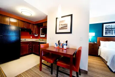 a kitchen and a room with a table and a bed at Residence Inn by Marriott Mississauga-Airport Corporate Centre West in Mississauga