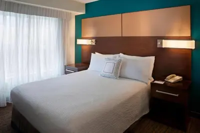 a hotel room with a large bed with white pillows at Residence Inn by Marriott Toronto Markham in Markham