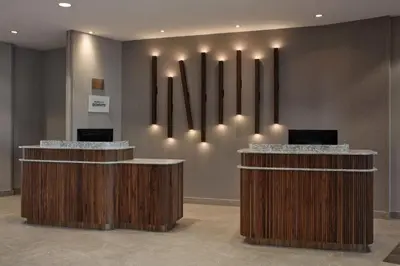 a lobby with two reception desks with lights on the wall at Courtyard by Marriott Mississauga-Airport Corporate Centre West in Mississauga