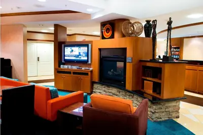 a living room with orange chairs and a television at Residence Inn by Marriott Toronto Vaughan in Vaughan
