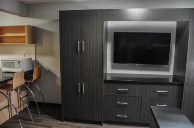 a large cabinet with a television on top of it at Residence & Conference Centre - Kitchener-Waterloo in Kitchener
