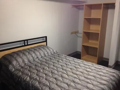 a bedroom with a bed and a book shelf at Residence & Conference Centre - Toronto in Toronto