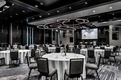 a conference room with white tables and chairs and a screen at Toronto Marriott Markham in Markham