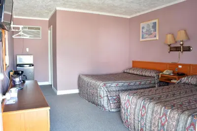 a hotel room with two beds and a table at Bracebridge Inn in Bracebridge
