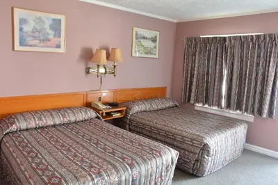 a hotel room with two beds and a window at Bracebridge Inn in Bracebridge