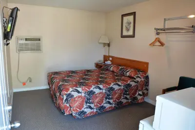 a bedroom with a bed with a floral bedspread at Bracebridge Inn in Bracebridge