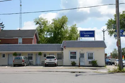 a building with cars parked in a parking lot at Bracebridge Inn in Bracebridge