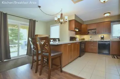 a kitchen with wooden cabinets and a table and chairs at Large modern ground floor condo at Mountain Walk in Blue Mountains