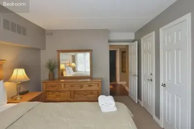 a bedroom with a bed with a dresser and a mirror at Large modern ground floor condo at Mountain Walk in Blue Mountains