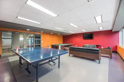 a room with a ping pong table and a couch at Residence & Conference Centre - Hamilton in Hamilton