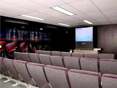 a classroom with chairs and a screen in a room at Residence & Conference Centre - Hamilton in Hamilton