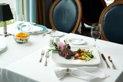 a white table with a plate of food on it at The Waterside Inn in Mississauga
