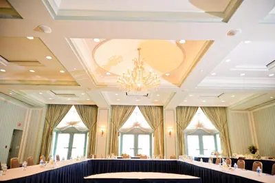 a banquet hall with a chandelier and tables at The Waterside Inn in Mississauga