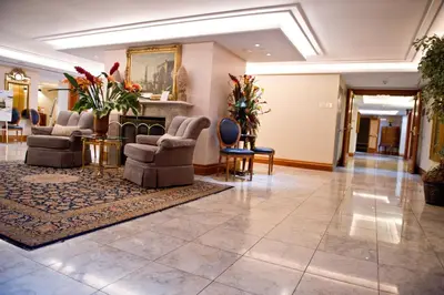 a lobby with chairs and tables and a fireplace at The Waterside Inn in Mississauga