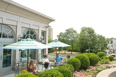 a group of people sitting at a table under umbrellas at The Waterside Inn in Mississauga