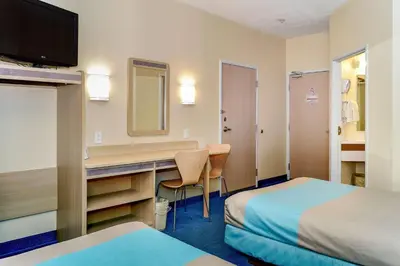 a hotel room with a desk and a mirror at Motel 6-Peterborough, ON in Peterborough