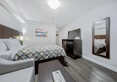 a hotel room with two beds and a mirror at Deluxe Inn in Toronto