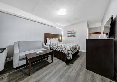 a hotel room with a bed and a couch at Deluxe Inn in Toronto