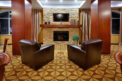 a lobby with two chairs and a fireplace at Holiday Inn Express Hotel & Suites Clarington - Bowmanville by IHG in Bowmanville