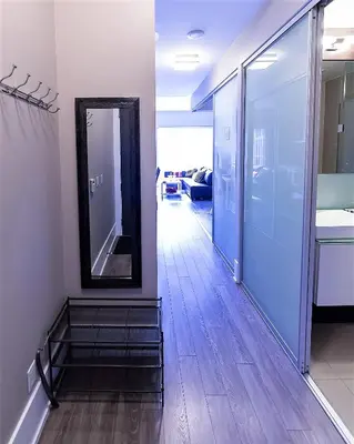 a hallway with a mirror on the wall and a staircase at Upscale Suite at CN Tower, Metro Convention & Rogers Centre in Toronto