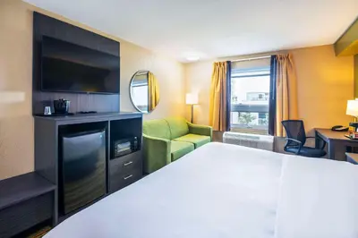 a hotel room with a bed and a living room at Quality Inn & Suites in Grimsby