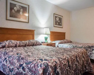 a hotel room with two beds and a lamp at Econo Lodge By the Falls in Niagara Falls