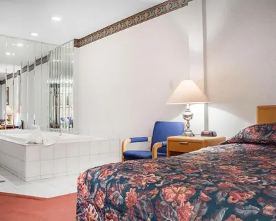 a hotel room with a bed and a bath tub at Econo Lodge By the Falls in Niagara Falls