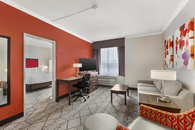 a hotel room with a desk and a bed at Best Western Plus Rose City Suites in Welland