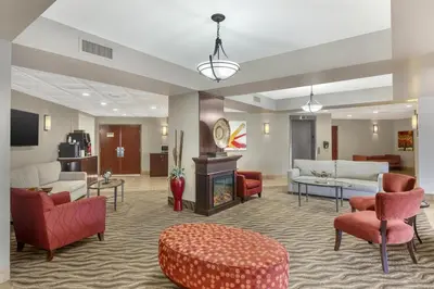 a living room with furniture and a fireplace at Best Western Plus Rose City Suites in Welland