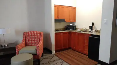 a small kitchen with a chair and a microwave at Best Western Plus Rose City Suites in Welland