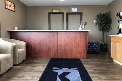 a bar in a room with a couch and a counter at Knights Inn Fort Erie in Fort Erie