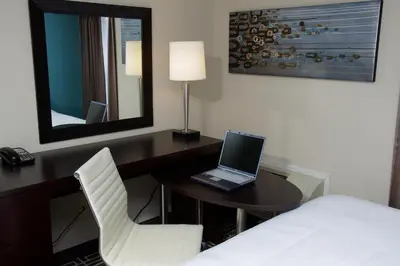 a hotel room with a desk with a laptop on it at Visitor's Inn in Hamilton