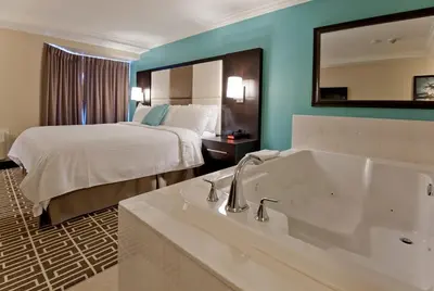 a hotel room with a bed and a bath tub at Visitor's Inn in Hamilton
